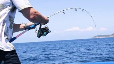 Tayland, Phuket 'te teknede balık tutan bir adam.