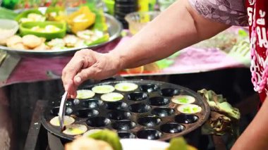 Yüzen bir pazarda Tayland hindistancevizli puding pişirmek