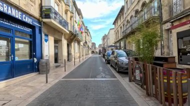Bayrakları ve park edilmiş arabaları olan sessiz bir cadde.