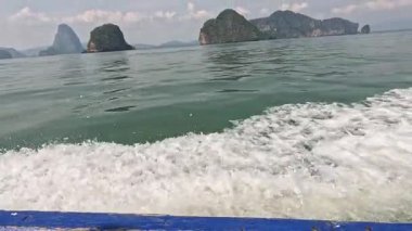 Tekne, pitoresk adaların yakınındaki suda seyahat ediyor.