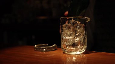 Barmen buzla dolu bardağa viski dolduruyor.