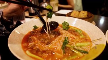 Melbourne 'da çubuklarla erişte yiyen biri.