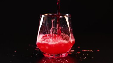 Kırmızı köpüklü içecek bardağa döküldü.