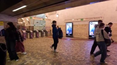 İnsanlar metro istasyonunda yürüyor.