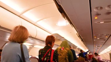 Tayland, Krabi 'de bir uçağa binen yolcular hareketli bir aktivite ve sıcak ışık ile canlı bir atmosfer yaratıyor.