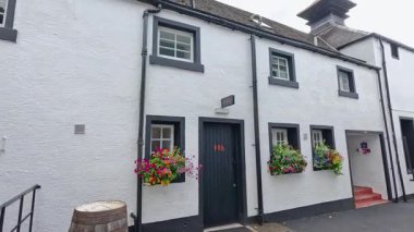 Çiçekleri ve bulutlu gökyüzü olan beyaz bina