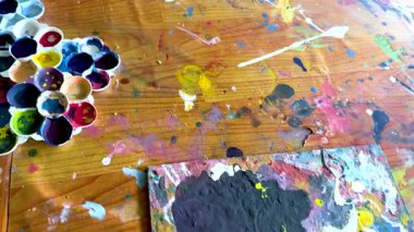 Ahşap bir yüzeye canlı bir boya serpintisi, dinamik renkler ve canlı bir ortamda sanatsal yaratıcılık sergiliyor.