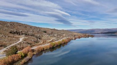 Drone görüntüleri, Yeni Zelanda, Cromwell 'deki sakin Dunstan Gölü' nü çevreleyen tepeler ve açık gökyüzü ile görüntüler. Pürüzsüz kamera hareketi sükuneti artırır