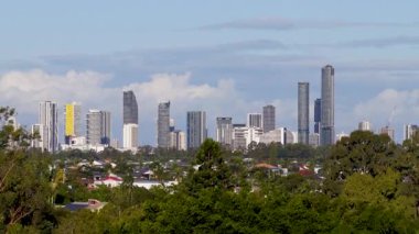 İnsansız hava aracı görüntüsü, açık mavi gökyüzünün altında yemyeşil ve golf sahası ile Gold Coast ufuk çizgisini yakalıyor.