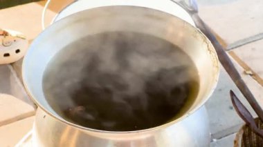 Dışarıdaki kaynayan bir tencereden buhar yükseliyor.