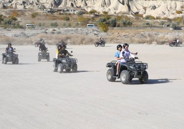 GOREME, NEVSEHIR, TURKEY-NOVEMBER 05: Kapadokya 'da ATV Gezisinin tadını çıkaran kimliği belirsiz gençler. 05.2022 Kasım, Goreme, Nevsehir, Türkiye