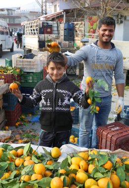 OVAKENT,HATAY,TURKEY-DECEMBER 10:Unidentified Funny Tangerine Sellers  at Local Farmers Market. December 10,2016 in Ovakent, Hatay, Turkey