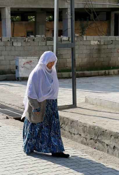 OVAKENT,HATAY,TURKEY-DECEMBER 10:Unidentified Older Uzbek  Woman with White hijab walking down the street. December 10,2016 in Ovakent, Hatay, Turkey