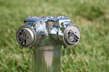 CARMEL,INDIANA,USA-MAY 30:Modern Chrome Fire Hydrant at Local Park covered with green grass. May 30,2013 in Carmel, IN