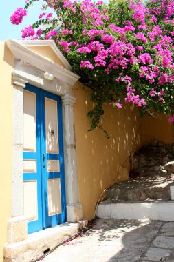 Yunanistan 'ın Symi kentindeki Güzel Kapı ve Pembe Bougainvillea Çiçekli Ev