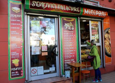 NOVI SAD, SERBIA-NOVEMBER 16: Kimliği belirsiz kadın bir fırından fırınlanmış gıdalar alıyor. 16 Kasım 2023 Novi Sad, Sırbistan