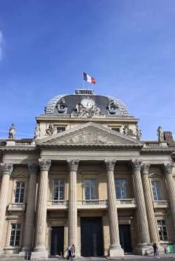 Paris, Fransa - 16 Haziran 2014: Fransız Bayrağı ve Mavi Gökyüzü Arkaplanı ile Eski Fransız Binası 'nın önünden yürüyen Tanımlanamayan İnsanlar