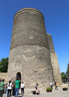 BAKU, AZERBAIJAN-JUNE 28,2024: Tanımlanamayan Turist Grubu Sıcak Bir Yaz Günü 'nde Tarihi Bakire Kulesi önünde duruyor