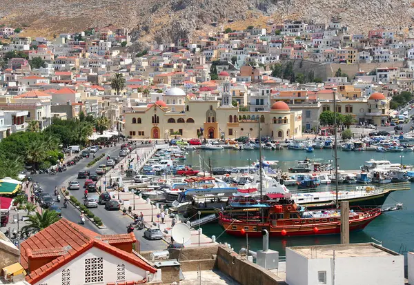 stock image KALYMNOS, GREECE-JULY 16,2013:Greek Orthodox Church, Buildings and Colorful  Boats at the Port