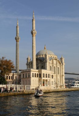 İSTANBUL, TURKEY-NOVEMBER 06.2021: Yüz Maskeli Tanımlanamayan İnsanlar ve Ortakoy Camii 'nin küçük balıkçı teknesi