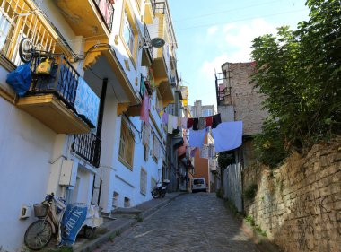 İSTANBUL, TURKEY- 11 Kasım 2021 Scooter, Bisiklet, Araba, İncir Ağacı ve Çamaşır ile Renkli Eski Sokak
