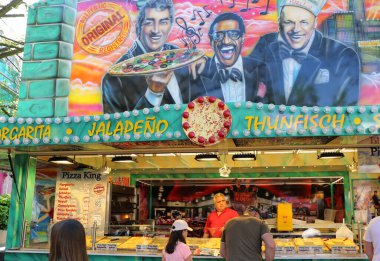 HERFORD, GERMANY-NİSAN 22,2019: Paskalya Festivali 'ndeki renkli bir pizzacıdan pizza almak için sırada bekleyen kimliği belirsiz insanlar