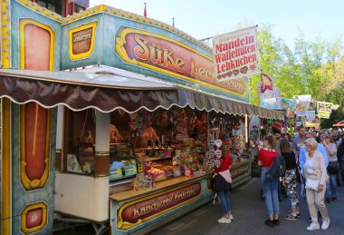 HERFORD, Almanya - 22 Nisan 2019 Paskalya Karnavalı 'nda Kimliği belirlenemeyen Müşteri Şeker Satıcısı' ndan şeker alıyor.