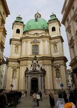 VIENNA, AUSTRIA-NOVEMBER 14,2023: St. Peters Katolik Kilisesi önünde duran ve Soğuk bir sonbahar gününde fotoğraf çeken kimliği belirsiz turistler