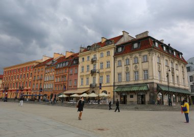 POLAND-MAYIS 15 Mayıs 2015: Castle Square yakınlarındaki Eski Şehir 'deki Renkli Eski Binaların önünden yürüyen kimliği belirsiz kişiler