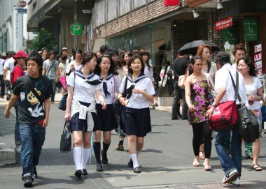 TOKYO, JAPAN-JULY 04,2008:Unidentified Young Men and Women walking down the Harajuku District  in a Hot Summer Day clipart