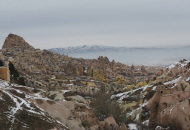 Nevsehir 'de Karlı Dağları, Peri Bacaları, Camileri ve Evleri Olan Uchisar Kasabası