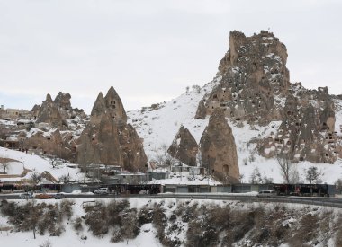 UCHISAR, NEVSEHIR, TURKEY-FEBRUARY 04.2017: Yol kenarındaki Uchisar Kalesi, Peri bacaları ve hediyelik eşya dükkanları