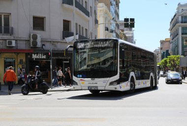 Selanik, Yunanistan-30 Nisan 20325: Güneşli bir bahar gününde Binalar ve İnsanlar 'ın yanından geçen Scooter, Otobüs ve Taksi
