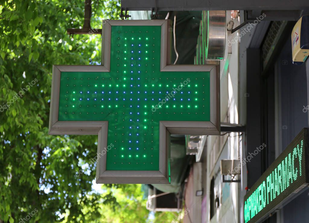 Thessaloniki, Greece-April 30,2025:Green Cross  Shaped Sign of the Pharmacies  in Europe