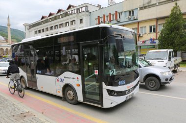 Prizren, Kosova-30 Mayıs 2025: Yolcularla Kamu Otobüsü, Bisikletli Adam ve Arka planda Sinan Paşa Camisi