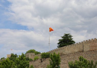 Makedonya 'nın Üsküp kentinde Kuzey Makedon bayrakları ve güzel gökyüzü olan Eski Üsküp Duvarları Şatosu