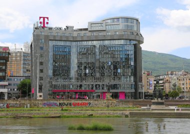 Üsküp, Kuzey Makedonya-28 Mayıs 2025: Telekom Makedonya İnşaat ve Vardar Nehri 'nden yürüyen Tanımlanamayan İnsanlar 