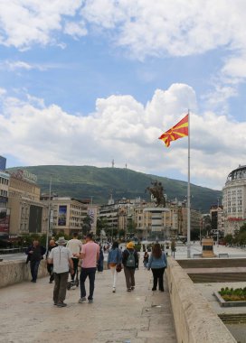 Üsküp, Kuzey Makedonya-28 Mayıs 2025: Kimliği belirsiz kişiler Taş Köprüyü geçip Çeşme Meydanı 'na doğru yürüyor. 