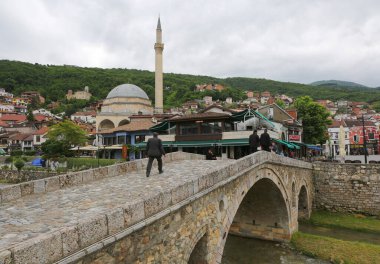 Prizren, Kosova-30 Mayıs 2025: Tanımlanamayan kişiler köprüden geçerek Şedervan Meydanı 'na doğru yürüyor 