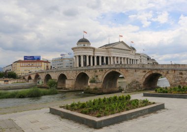 Üsküp, Kuzey Makedonya-28 Mayıs 2025: Vardar Nehri üzerindeki Arkeoloji Müzesi 'nin Taş Köprü' sünde yürüyen Tanımlanamayan İnsanlar