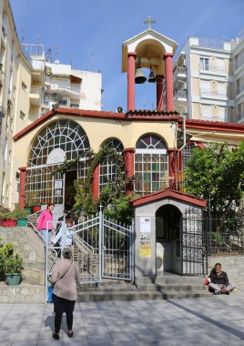 Selanik, Yunanistan-23 Nisan 2025: Kimliği belirsiz kişiler Çan Kulesi ve Renkli Gözlükler ile kiliseden ayrılıp dilencilik yaparak para istiyorlar