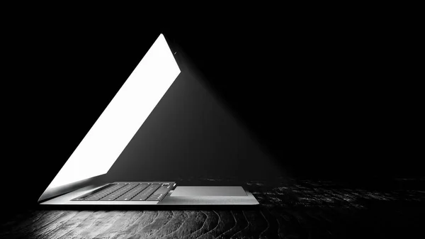 在昏暗的背景上显示光芒的笔记本电脑屏幕 免版税图库图片