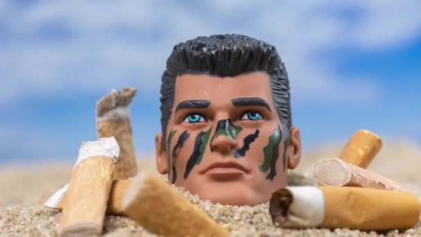 Чоловіча Голова Ляльки Оточена Цигарками Заповнюють Красивий Пляж — стокове відео