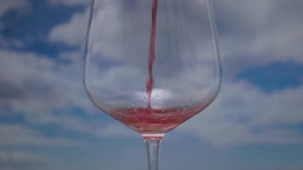 Una Copa Con Vino Tinto Vierte Cámara Lenta Con Nubes — Vídeo de stock