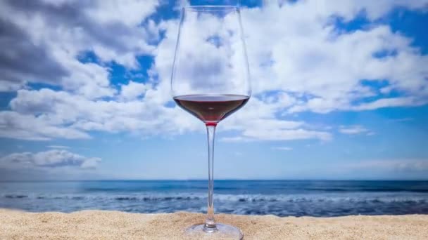 Sahilde Kırmızı Şarap Bardağı Arkasında Hareket Eden Bulutlar Var — Stok video