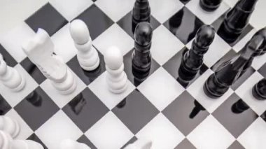 Beyaz bir arkaplana karşı stop hareketinde bir satranç oynanıyor