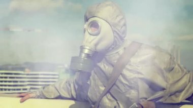 Kimyasal gaz saldırısı sırasında gaz kıyafeti giymiş bir adam etrafa bakıyor.