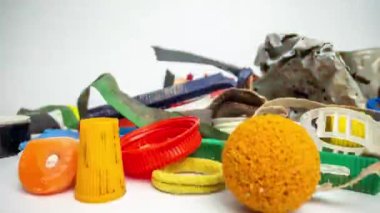 Plastik atık ve atık maddelerden oluşan renkli pullu bir koleksiyon boyunca çekilen bir ekran makrosu