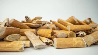 Beyaz arka planda sigara izmaritlerinin makro görüntülerini tarıyorum.