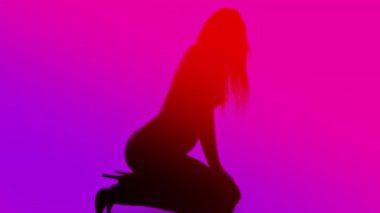 Sadece diz boyu çizme giyen güzel bir dişi parlak neon renklerle poz veriyor.